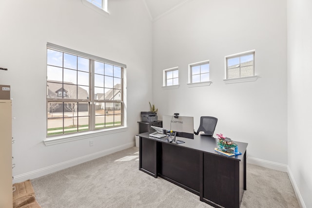 home office with crown molding, baseboards, light carpet, and high vaulted ceiling