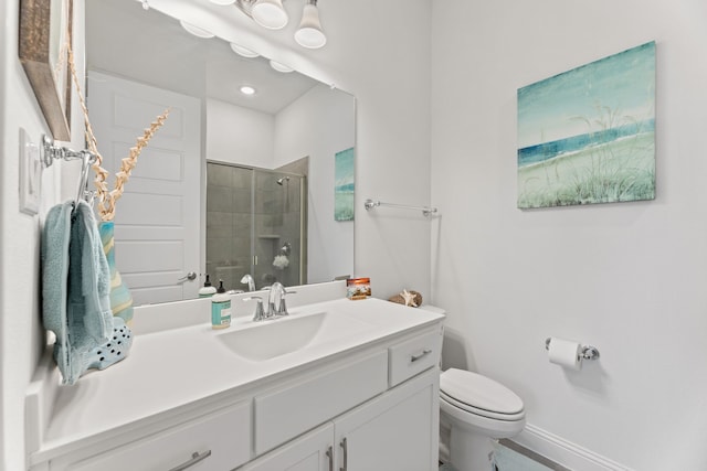 full bathroom featuring a stall shower, baseboards, vanity, and toilet