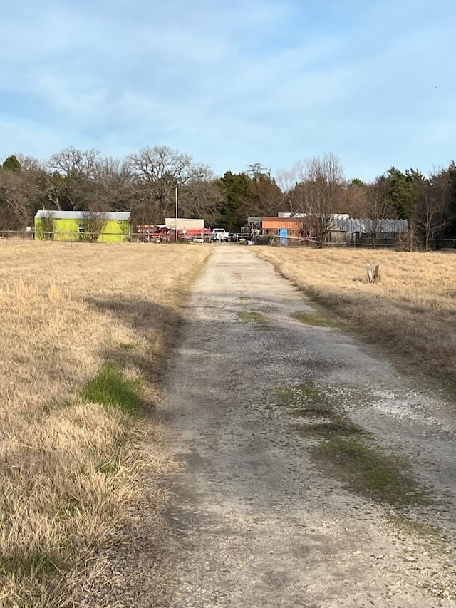 view of street with driveway and a rural view