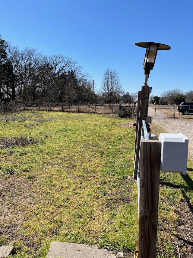 view of yard with fence and a rural view