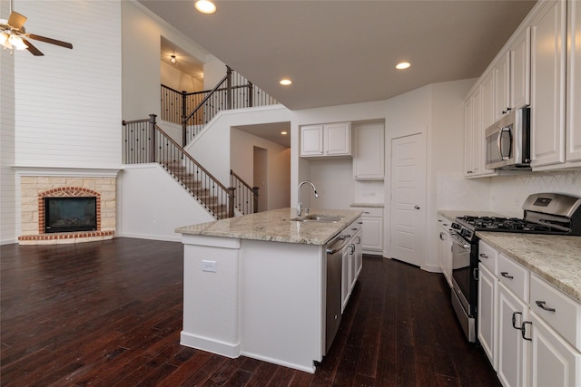 kitchen with white cabinets, dark wood-style flooring, stainless steel appliances, a sink, and recessed lighting