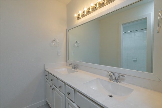 full bath featuring double vanity, baseboards, and a sink