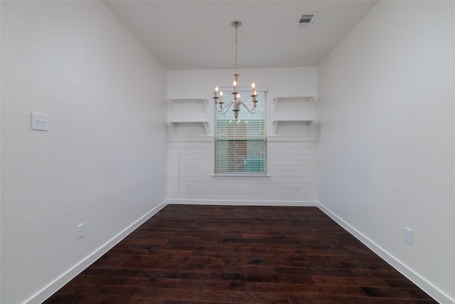 unfurnished dining area with baseboards, visible vents, a chandelier, and wood finished floors