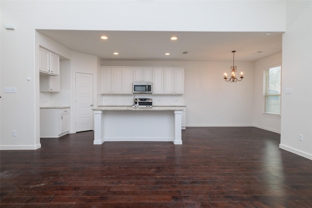 kitchen featuring a chandelier, recessed lighting, stainless steel appliances, dark wood-type flooring, and white cabinetry