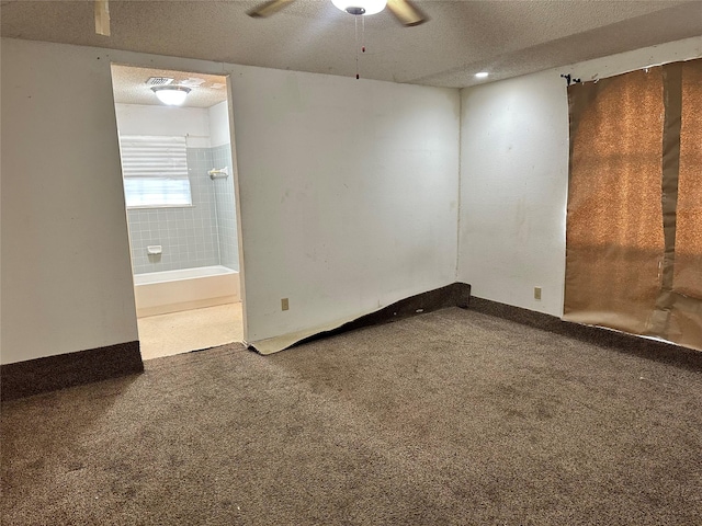 carpeted spare room featuring ceiling fan, a textured ceiling, and baseboards