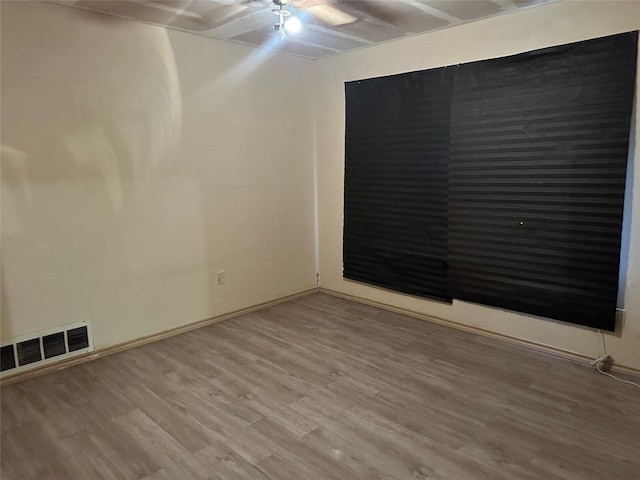 unfurnished room with visible vents and wood finished floors