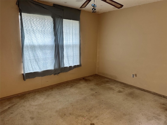 empty room featuring ceiling fan, carpet floors, and baseboards