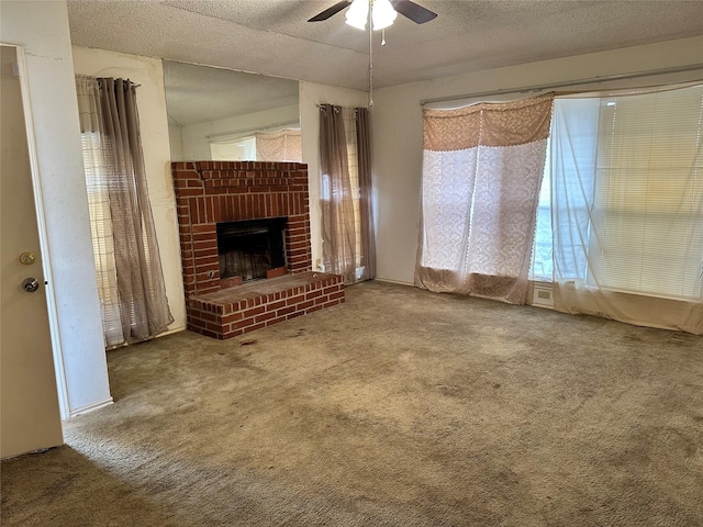 unfurnished living room with a textured ceiling, ceiling fan, carpet, and a fireplace