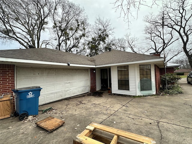 ranch-style house with a garage, concrete driveway, brick siding, and a shingled roof