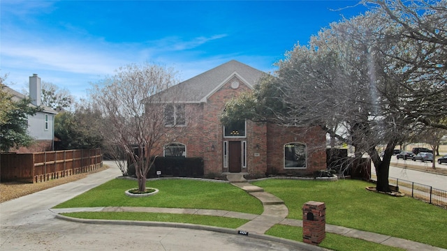 view of front of home featuring brick siding, a front yard, and fence