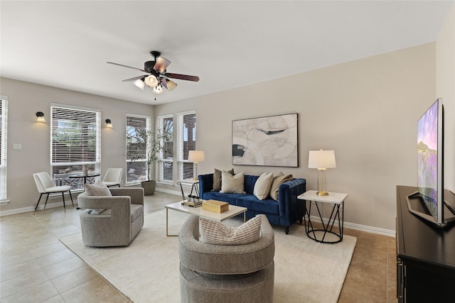 living room with light tile patterned floors, baseboards, and a ceiling fan