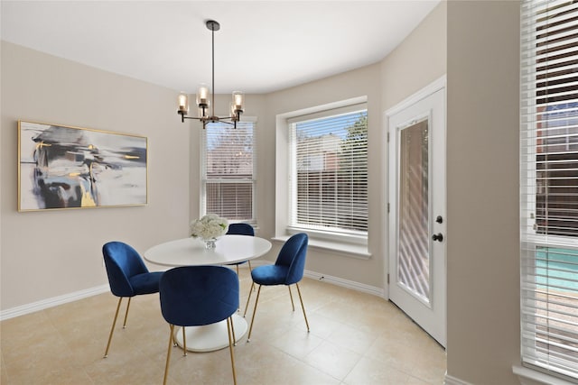 tiled dining room with an inviting chandelier and baseboards