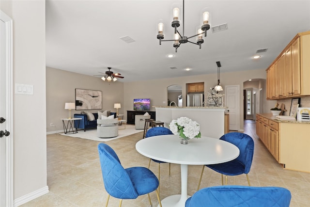 dining space with visible vents, arched walkways, and ceiling fan with notable chandelier