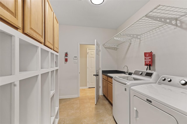 laundry room featuring washer and clothes dryer, cabinet space, baseboards, and a sink