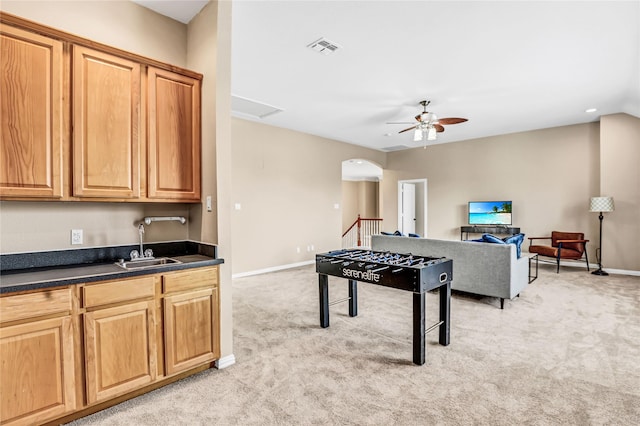 rec room with visible vents, a ceiling fan, a sink, baseboards, and light colored carpet