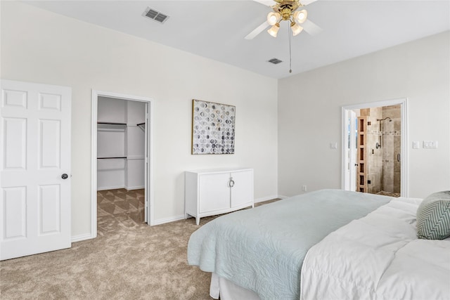 bedroom with visible vents, baseboards, a walk in closet, and carpet