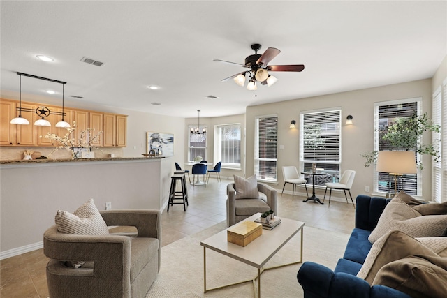 living area featuring visible vents, baseboards, light tile patterned floors, ceiling fan with notable chandelier, and recessed lighting