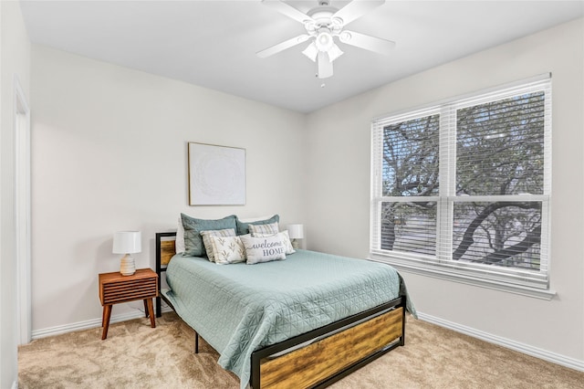 bedroom with ceiling fan, baseboards, and light carpet