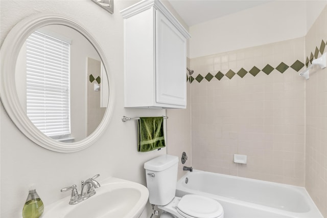 bathroom with bathtub / shower combination, toilet, and a sink