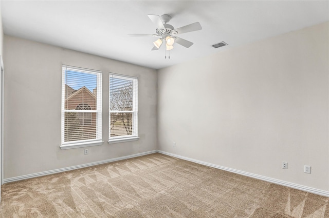 carpeted empty room featuring visible vents, baseboards, and a ceiling fan