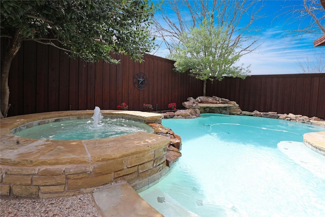 view of pool with a fenced backyard and a pool with connected hot tub