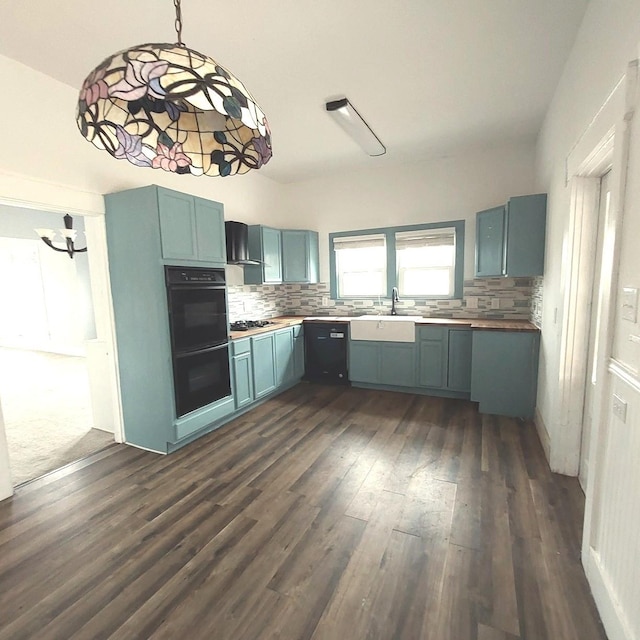 kitchen featuring a sink, wall chimney range hood, dark wood-type flooring, and backsplash