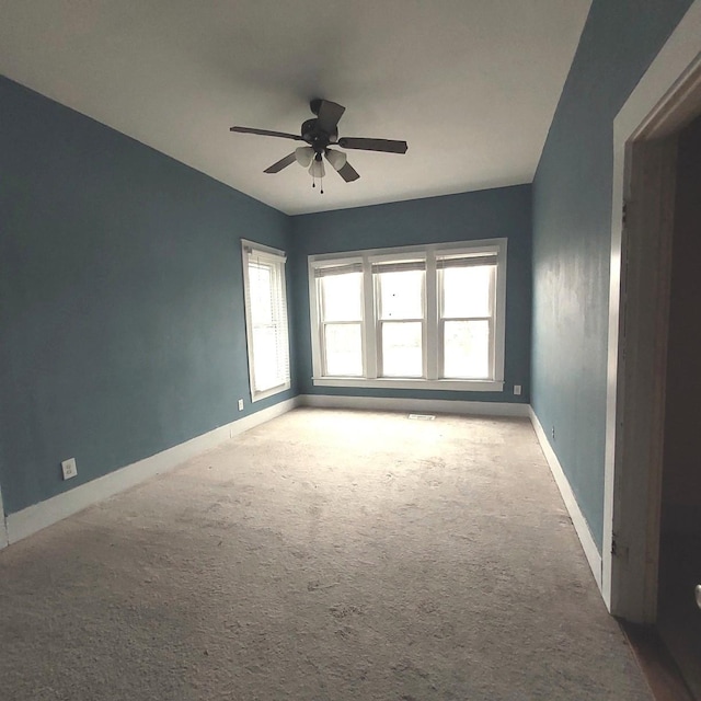 unfurnished room with carpet, baseboards, and a ceiling fan