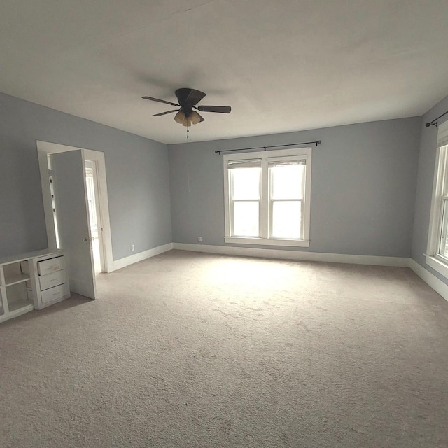 unfurnished room featuring a ceiling fan, carpet flooring, and baseboards