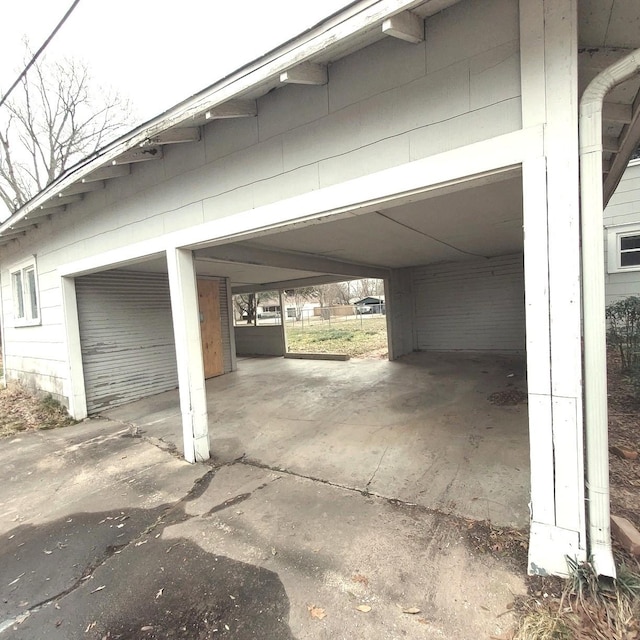 garage featuring a carport and driveway