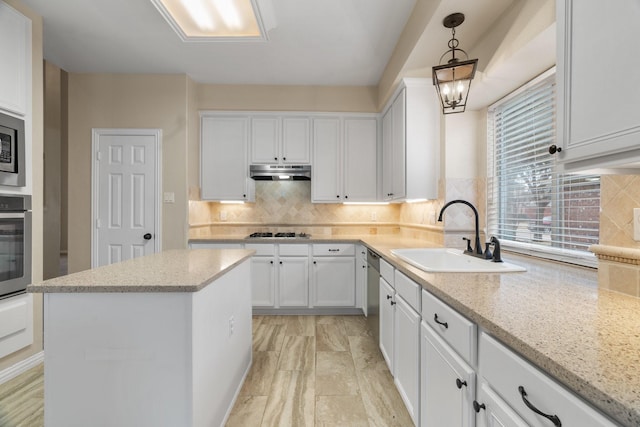 kitchen with stainless steel appliances, white cabinetry, a sink, and under cabinet range hood