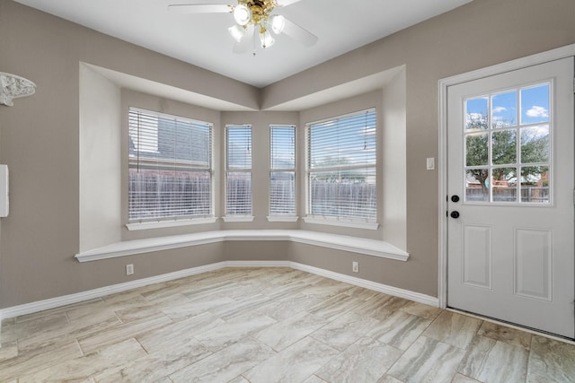 interior space with ceiling fan and baseboards