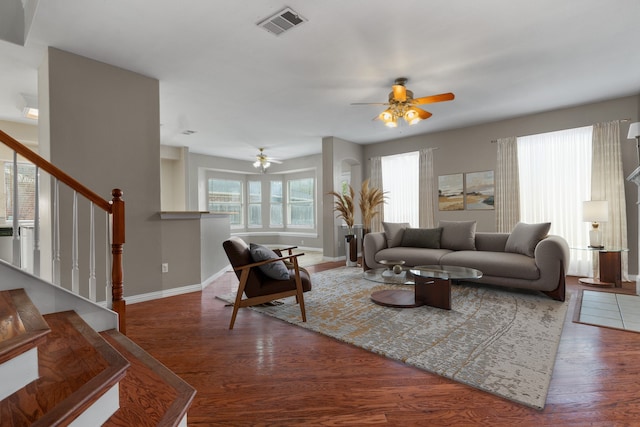 living room featuring stairs, wood finished floors, visible vents, and baseboards