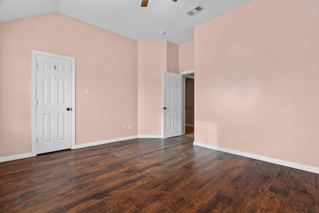 empty room with dark wood finished floors, visible vents, a ceiling fan, vaulted ceiling, and baseboards