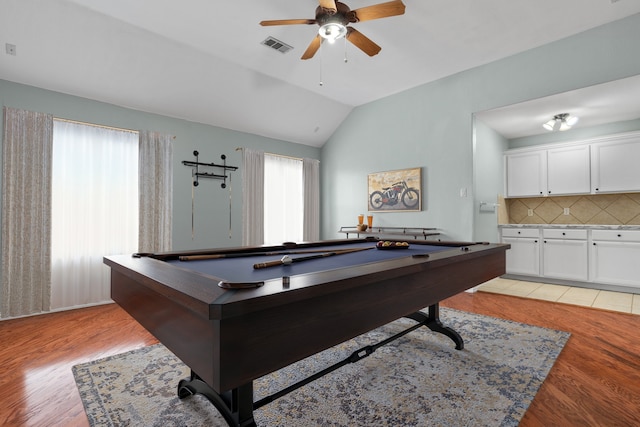 recreation room with lofted ceiling, light wood-style flooring, visible vents, and a ceiling fan