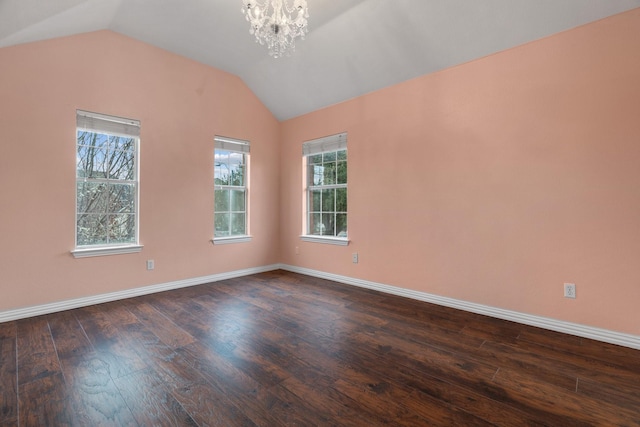 empty room featuring dark wood-style floors, lofted ceiling, baseboards, and an inviting chandelier