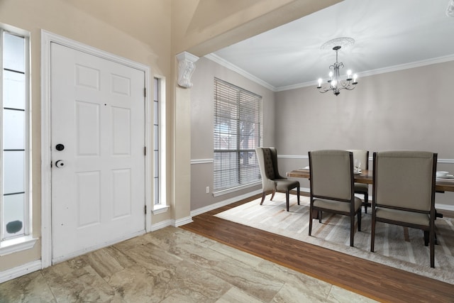 dining space featuring crown molding, baseboards, wood finished floors, and an inviting chandelier