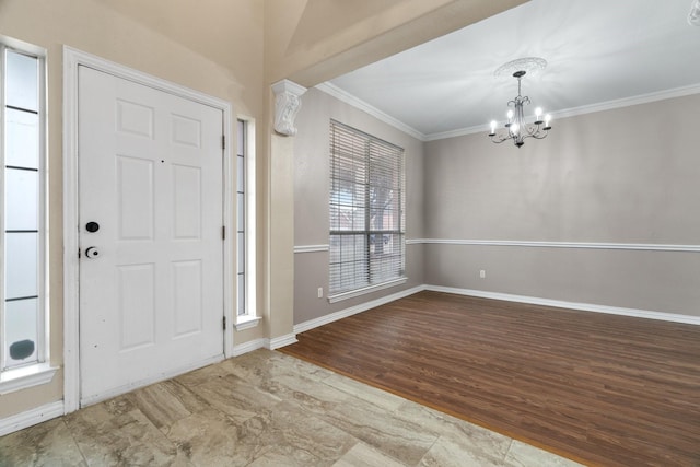 foyer with a chandelier, crown molding, baseboards, and wood finished floors