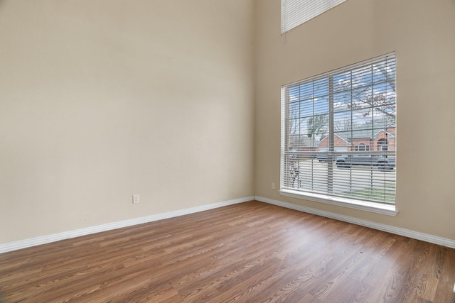 unfurnished room with baseboards and wood finished floors