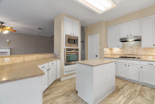 kitchen featuring visible vents, decorative backsplash, appliances with stainless steel finishes, under cabinet range hood, and white cabinetry