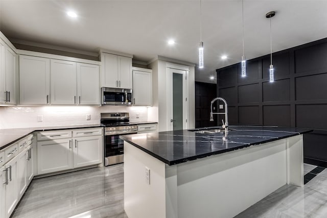 kitchen with pendant lighting, stainless steel appliances, a decorative wall, decorative backsplash, and white cabinets