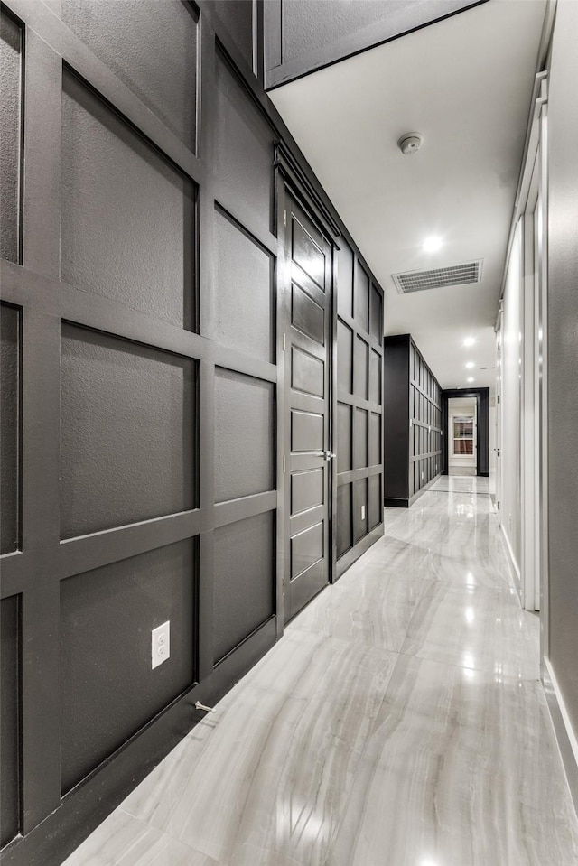 hallway with visible vents and a decorative wall