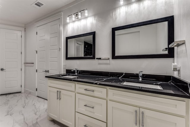 full bath featuring marble finish floor, double vanity, a sink, and visible vents