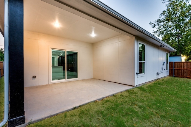 back of property with a yard, a patio area, and fence