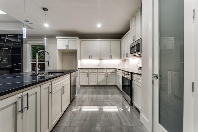 kitchen with tasteful backsplash, visible vents, appliances with stainless steel finishes, pendant lighting, and a sink