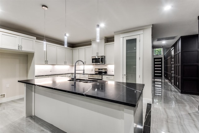 kitchen featuring stainless steel appliances, a sink, white cabinetry, marble finish floor, and tasteful backsplash