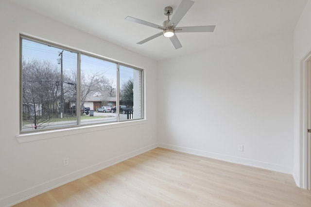 unfurnished room with light wood-type flooring, a ceiling fan, and baseboards