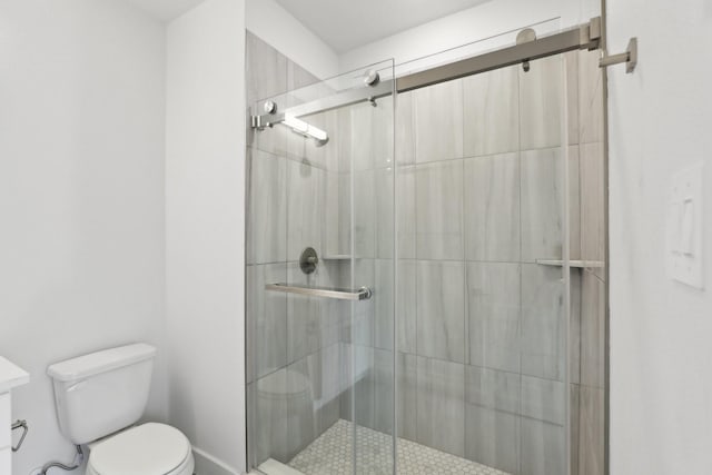 bathroom featuring a stall shower and toilet