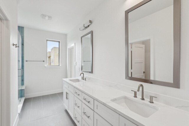 bathroom featuring tile patterned flooring, a sink, baseboards, and double vanity