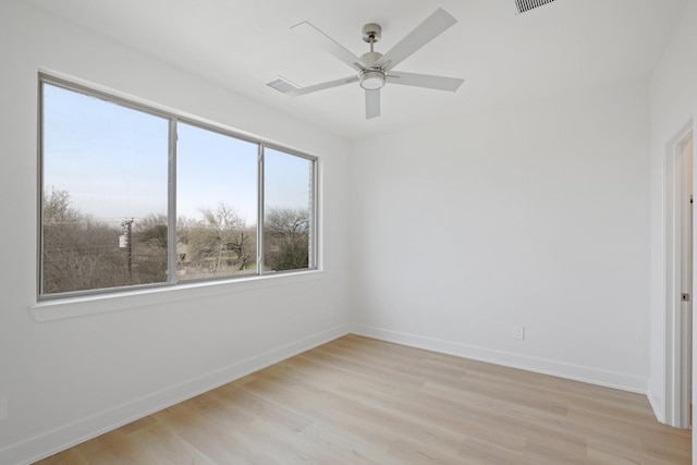 unfurnished room featuring a ceiling fan, visible vents, light wood-style flooring, and baseboards