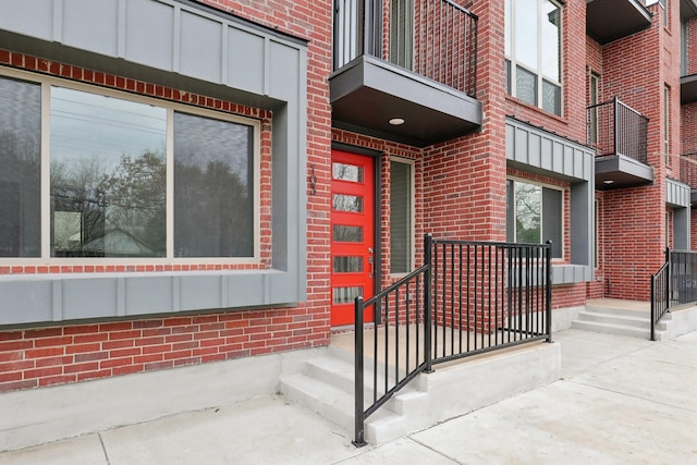 property entrance with board and batten siding and brick siding